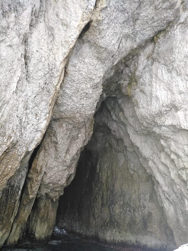 L'imboccatura della grotta da vicino. La volta è appuntita, l'ingresso sembra un triangolo che ha per base il mare